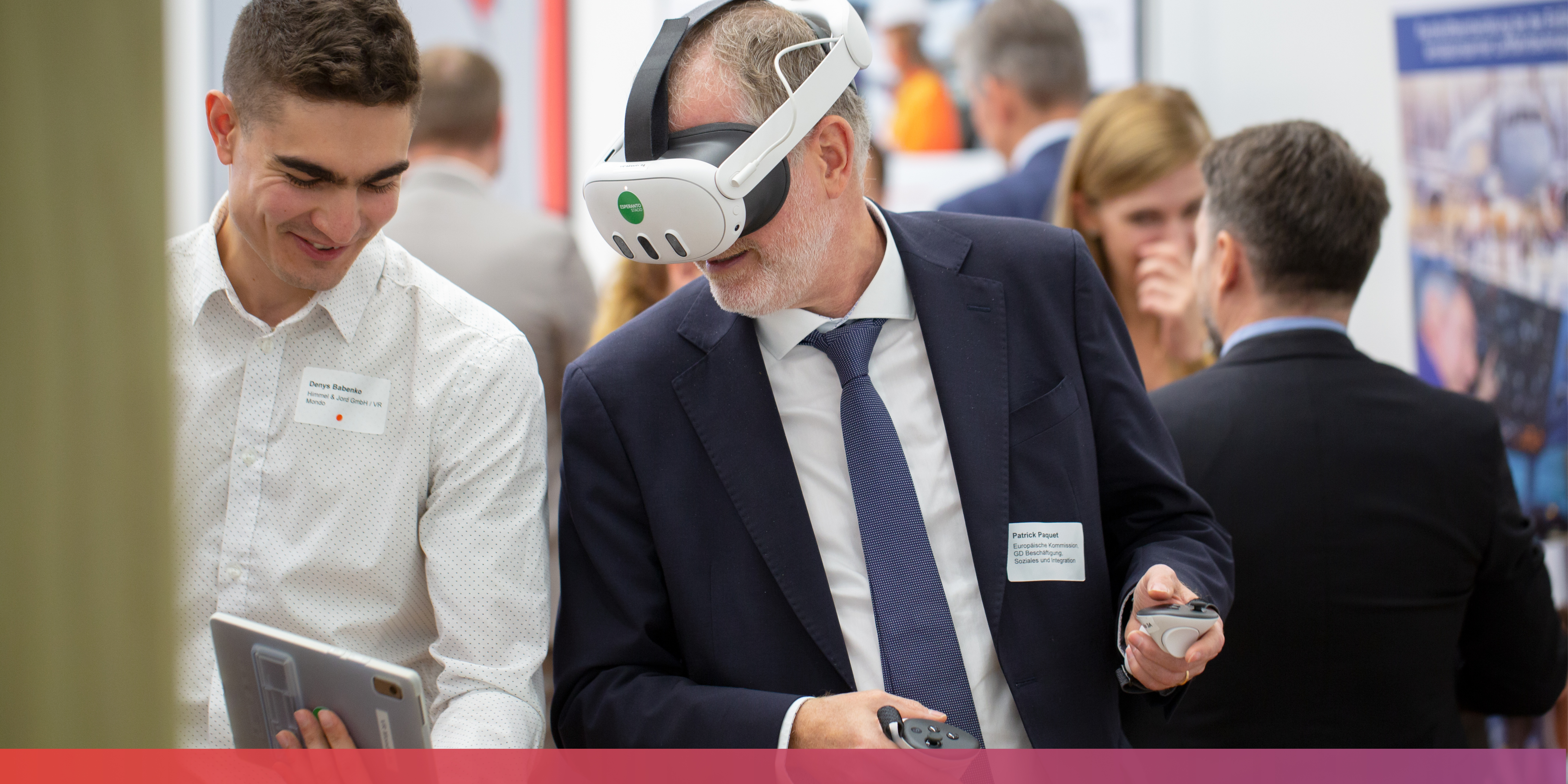 Bild: Patrick Paquet von der EU-Kommission mit VR-Brille auf dem Kopf. Er blickt auf ein Tablet, das ihm ein Mitarbeiter des Projektes hinhält.